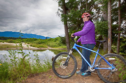 Woman on a dirt trail with her bicycle