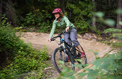 Woman biking along a path in the forest