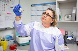 Woman wearing scrubs holding sample