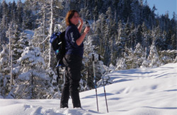 Woman walking through the snow wearing winter gear