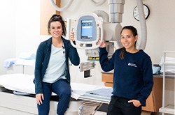 Two care workers holding a machine